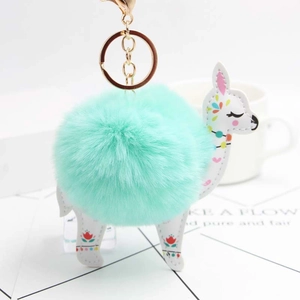 Detail of mint green plush ball keychain with floral white leather alpaca charm and gold clasp