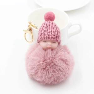 Portachiavi bambola di peluche rosa con pompon e cappello a maglia su tazza di ceramica