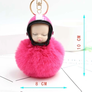Detail of sleeping baby doll keychain with pink helmet and 8cm soft pompom fur ball