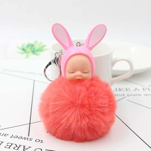 Sleeping baby doll keychain with plush red pompom and rabbit ears for bag decoration