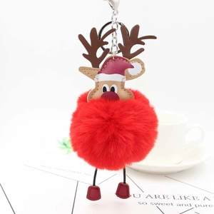 Detailed close-up of a Christmas reindeer plush pompom keychain with red faux fur ball