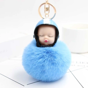 Detailed macro view of the fluffy blue pompom with a cute baby face in a helmet