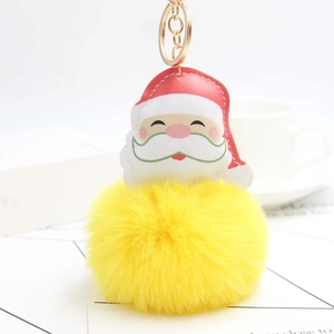 Close-up of Santa Claus leather charm with a large yellow plush ball and gold keychain