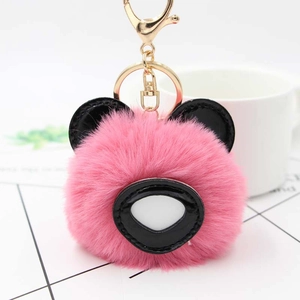 Détail d'un porte-clés panda en peluche rose avec oreilles en cuir et fermoir en métal doré