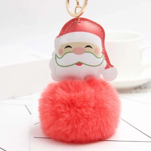 Detail of Santa Claus plush keychain with soft red faux fur ball and golden metal ring