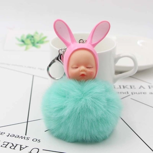 Cute sleeping baby doll keychain with mint green pompom and pink bunny ears for bags