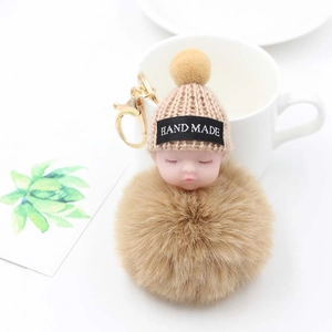Détail du porte-clés bébé endormi fait main avec pompon en peluche et fermoir doré