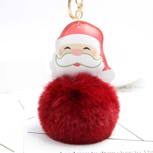 Detail of Santa plush keychain with faux leather head, red fluffy pompom and gold metal ring