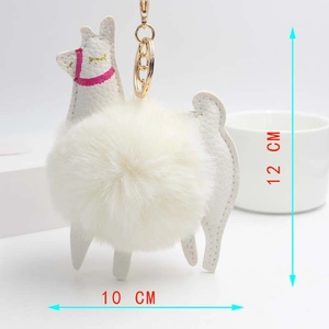Detail view of white alpaca plush keychain with dimensions 10cm x 12cm and gold hook