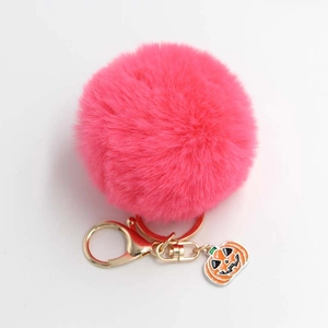 Porte-clés pompon en fausse fourrure rose avec pendentif citrouille d'Halloween doré