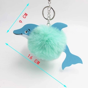 Detailed plush dolphin keychain with mint green fur and blue leather fins, 16cm size view
