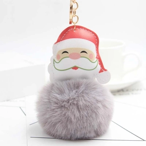 Detailed macro shot of grey faux fur pompom and cartoon Santa Claus keychain pendant
