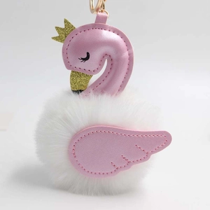 Détail du porte-clés cygne blanc pelucheux avec ailes roses et couronne dorée brillante