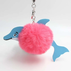 Detailed view of a pink plush pom-pom dolphin keychain with blue textured leather and silver hook