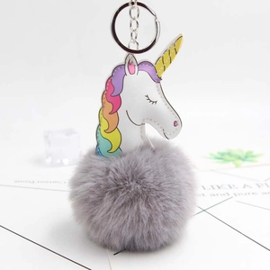 Détail du porte-clés pompon licorne en peluche avec fausse fourrure et crinière arc-en-ciel