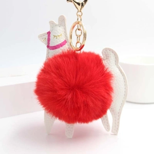 Detailed view of white PU leather alpaca keychain with large fluffy red fur pompom