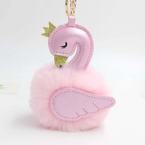 Détail d'un porte-clés cygne rose en peluche avec corps en fausse fourrure et couronne dorée