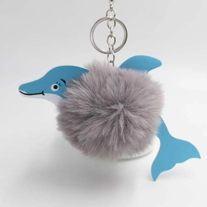 Detailed view of blue dolphin keychain with soft grey faux fur ball and silver metal ring