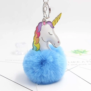 Détail du pompon en fausse fourrure bleue et du porte-clés licorne en cuir