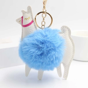 Close-up of white leather alpaca keychain with a soft sky blue fluffy pompom and gold ring