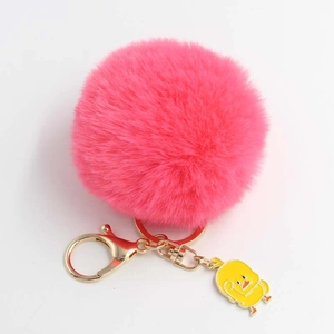 Dettaglio portachiavi con palla di pelo rosa vivace, chiusura dorata e ciondolo a forma di papera