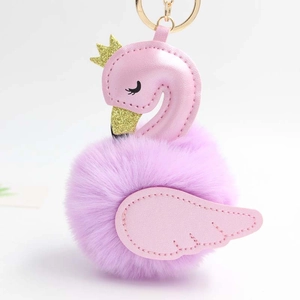 Détail de porte-clés cygne rose avec couronne dorée et pompon en peluche violette douce