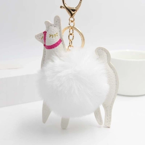 Detailed close-up of a white alpaca keychain with fluffy pompom and gold lobster clasp
