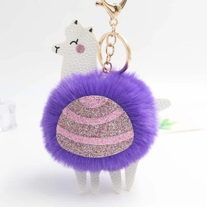 Close-up of purple alpaca fluffy pompom keychain with pink sequins and gold hardware