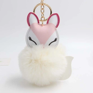 Detailed close-up of a pink fox plush keychain with a soft white fluffy pom-pom charm