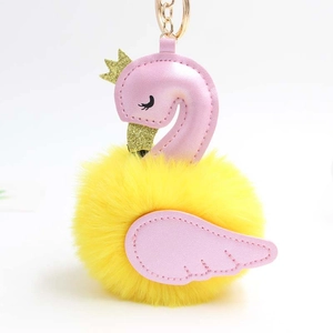 Détail du porte-clés cygne en peluche rose avec pompon jaune et anneau doré