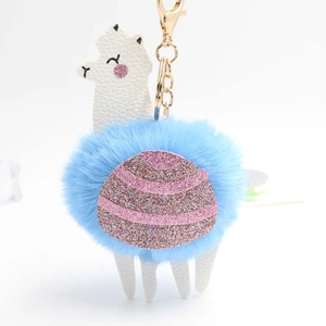 Detail of white faux leather alpaca keychain with blue plush fur and pink sequins