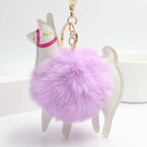 Detail of alpaca keychain with a fluffy purple pom-pom and white leather texture
