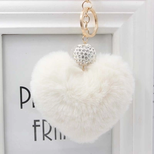 Dettaglio portachiavi a cuore in peluche bianco con sfera di strass e anello d'oro