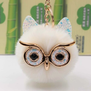 Vue détaillée du porte-clés hibou blanc en peluche avec fermoir mousqueton doré