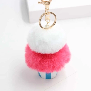 Close-up of fluffy ice cream plush keychain with gold lobster clasp and blue striped cup