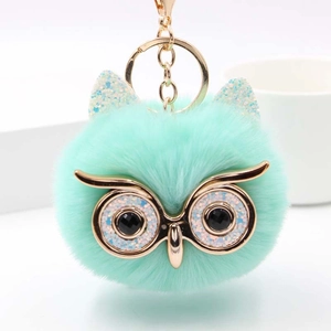 Détail de porte-clés chouette en peluche vert menthe avec yeux dorés pailletés