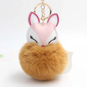 Detailed view of fox plush keychain with fluffy brown fur ball and golden metal ring