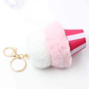 Detailed view of pink and white plush ice cream keychain with golden lobster clasp