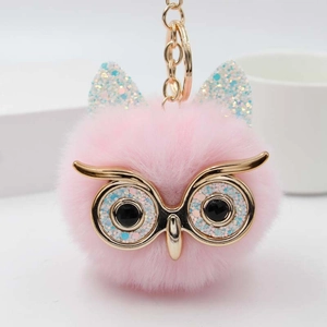 Détail du porte-clés hibou rose en peluche avec yeux à paillettes et métal doré
