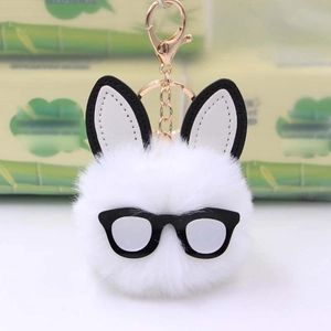 Close-up of white fluffy plush rabbit keychain with leather ears and glasses