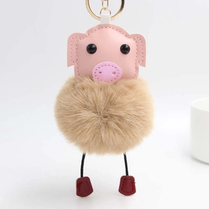 Détail du porte-clés cochon en peluche avec face en cuir rose et crochet doré