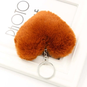 Dettaglio di un portachiavi in peluche a forma di cuore marrone caramello con anello in metallo