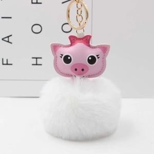 Détail d'un porte-clés cochon rose mignon avec pompon blanc et crochet en métal doré