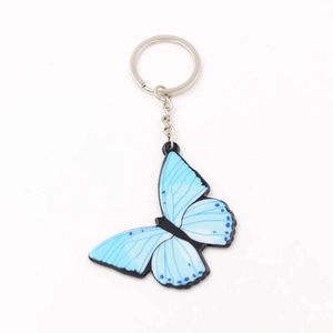 Vue détaillée d'un porte-clés papillon bleu en acrylique avec chaîne et anneau argentés