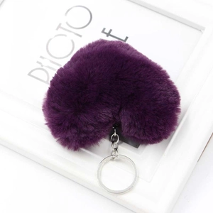 Dettaglio del portachiavi a cuore in finta pelliccia viola scuro con moschettone in metallo