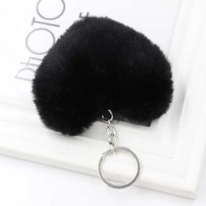 Dettaglio di un portachiavi a cuore in peluche nera con anello e catena in metallo