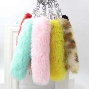Detailed view of colorful faux fur fox tail keychains with silver metal attachments