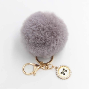 Light purple fluffy pompom keychain with golden clasp and pearl bow charm accessory