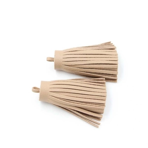 Detail view of two beige PU leather tassels with hanging loops for bags or keychains