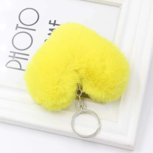Dettaglio di un portachiavi a cuore in peluche giallo con anello in metallo argento